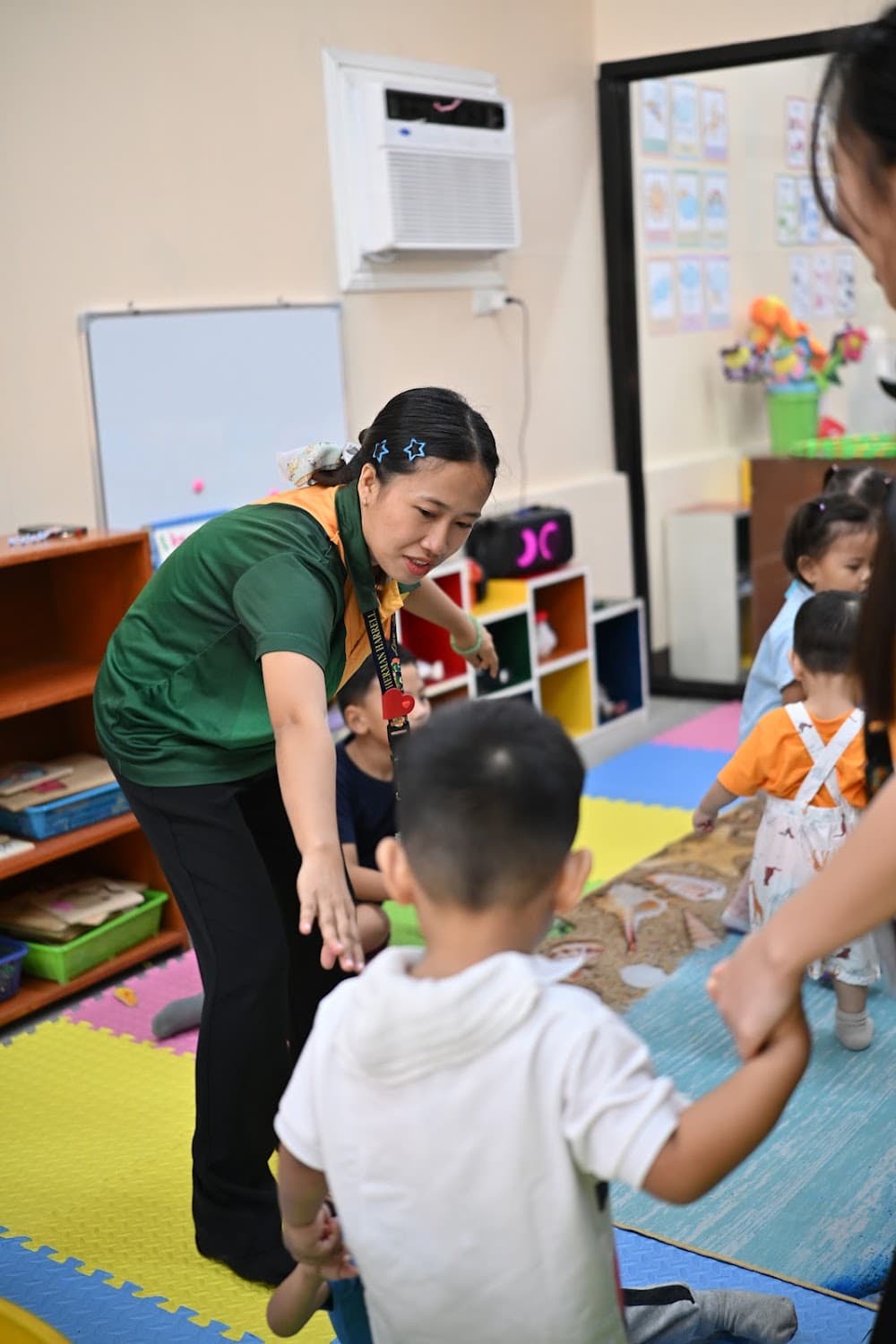 A teacher greeting children as they arrive for the day