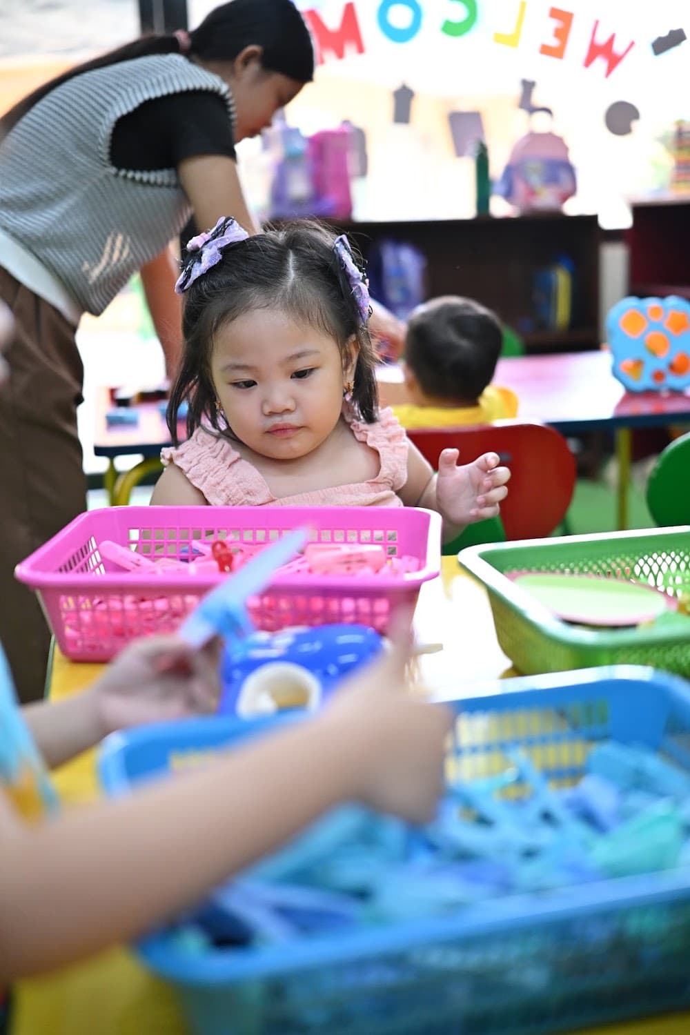 A girl focused on a fine-motor sorting activity at a table