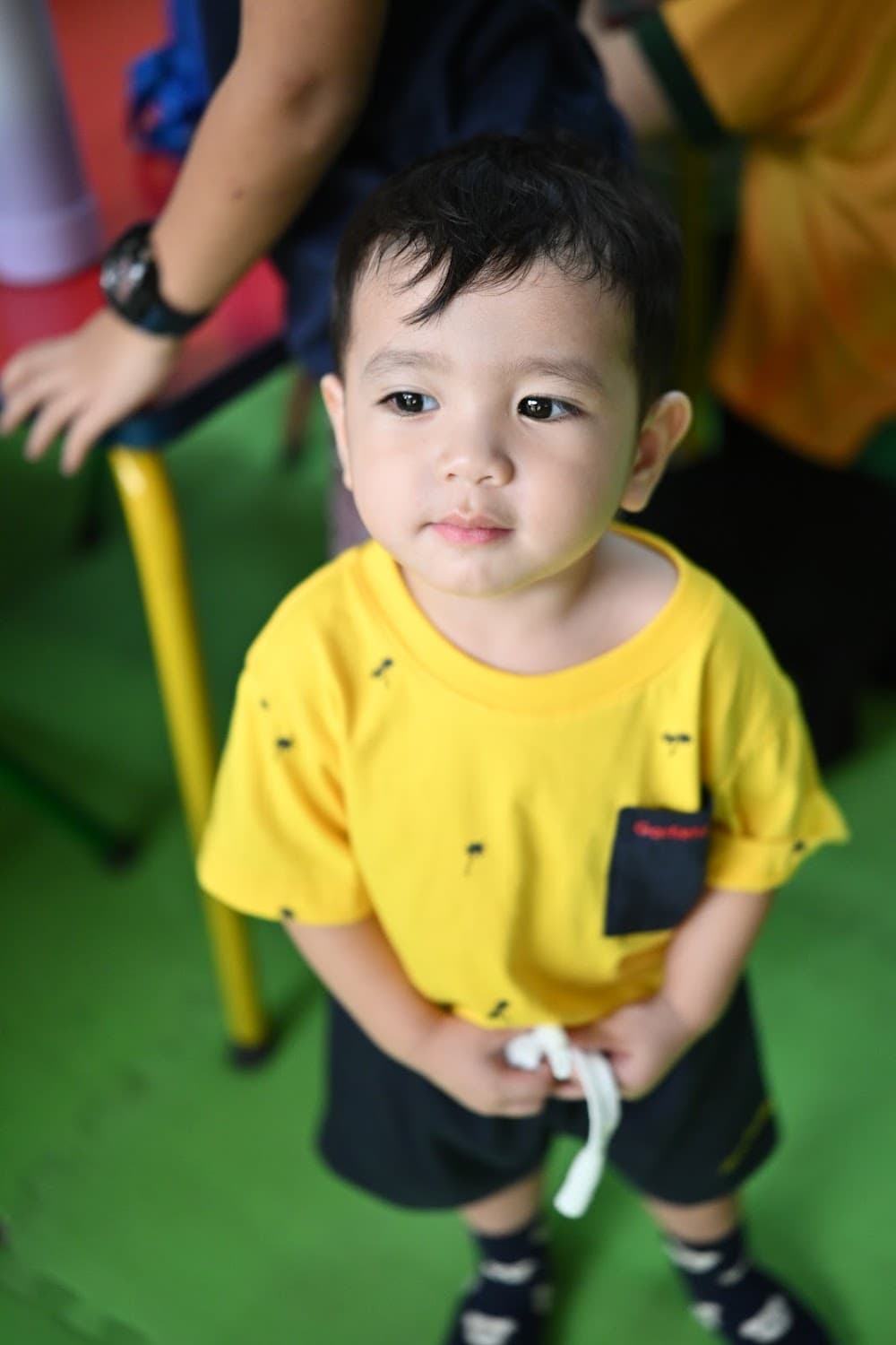 Close-up of a toddler boy in his yellow uniform