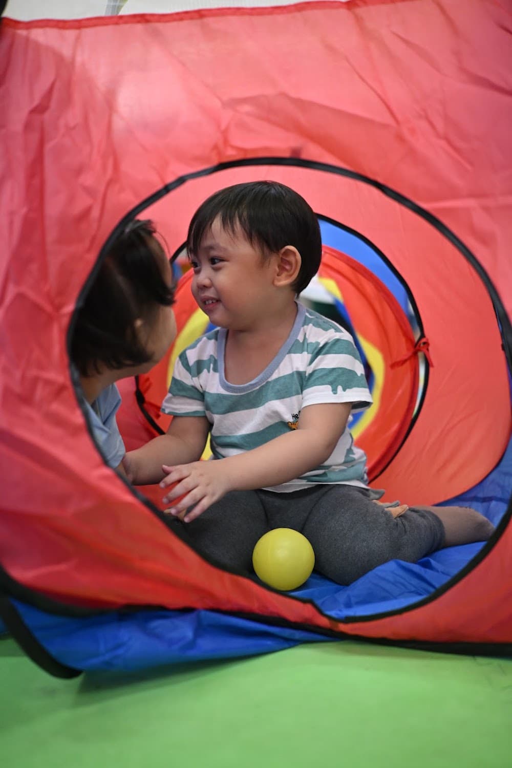 Two boys doing a sensory water-scooping activity