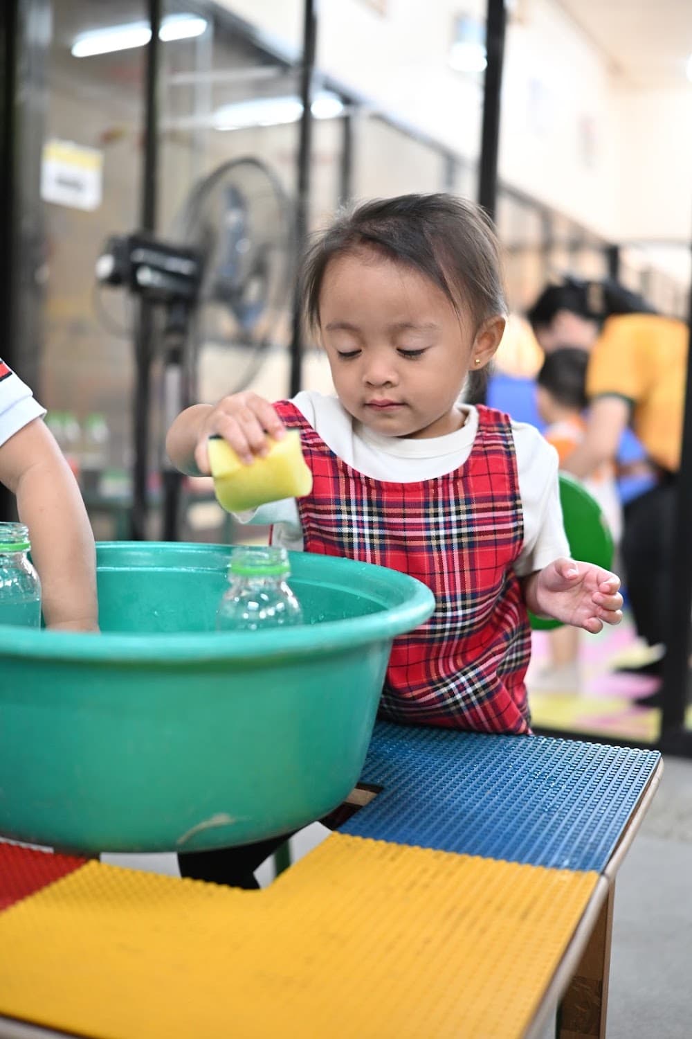 A teacher and children playing with a toy hose activity